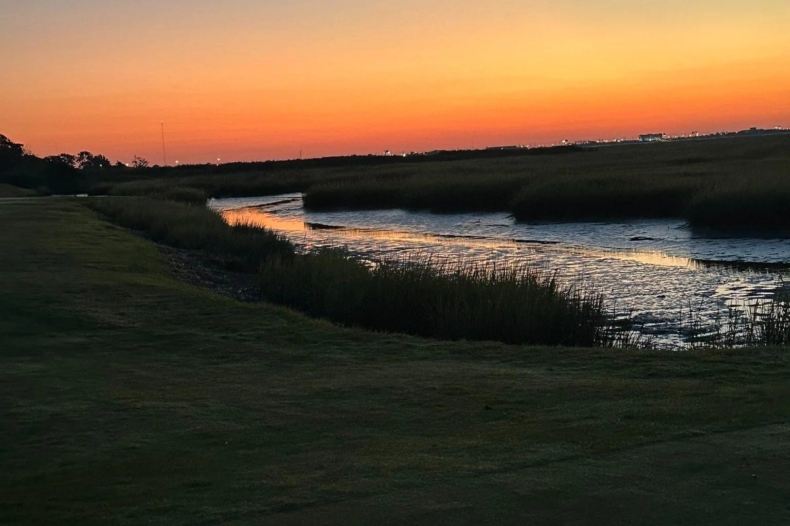 Sunset over the marsh beside the course